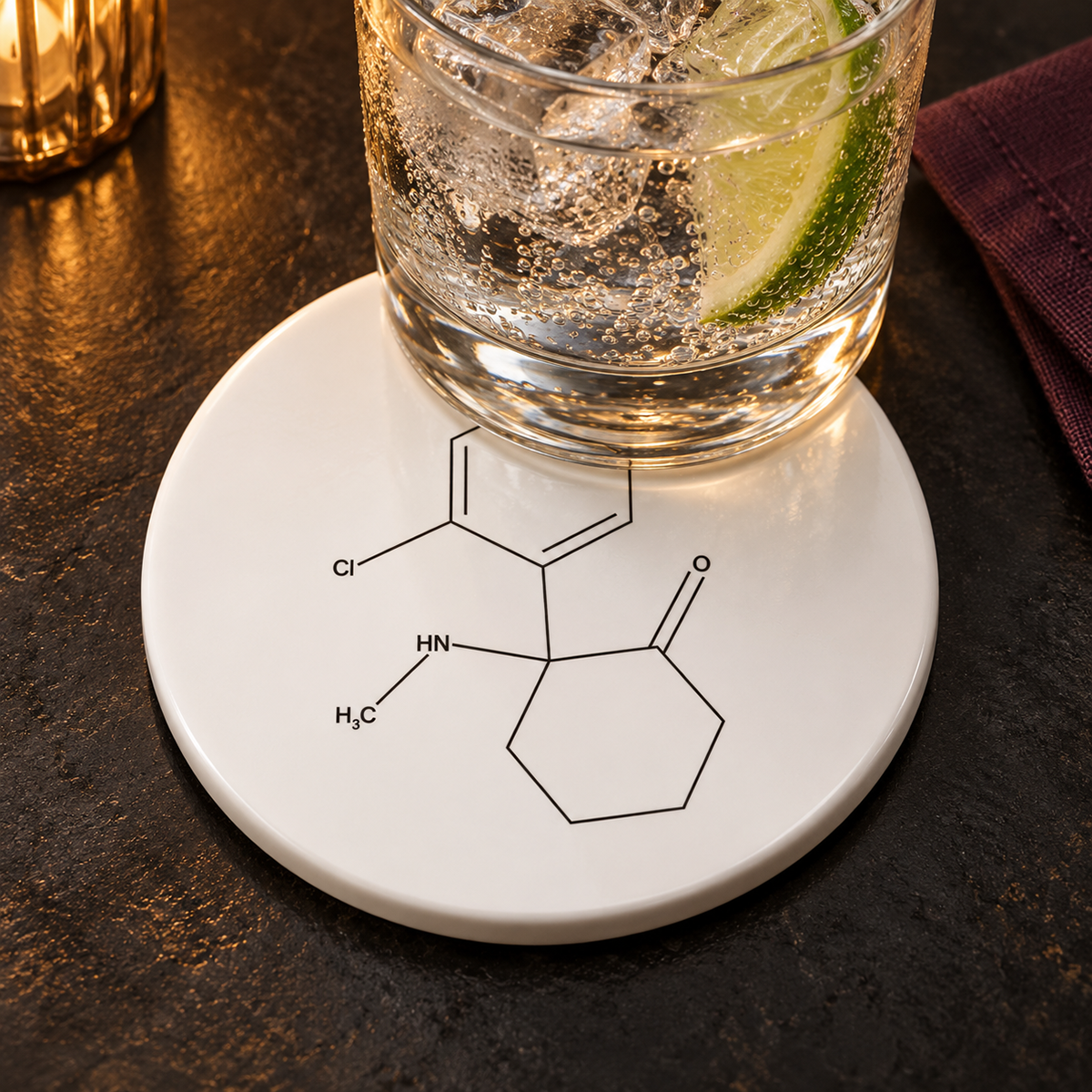A clear lime-and-soda drink rests on a white ceramic Ketamine molecule coaster in the No Names style.